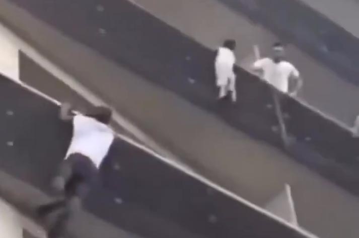 Shocking clip of baby hanging from high-rise apartment railing